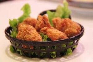 a basket of fried chicken sitting on top of some lettuce 